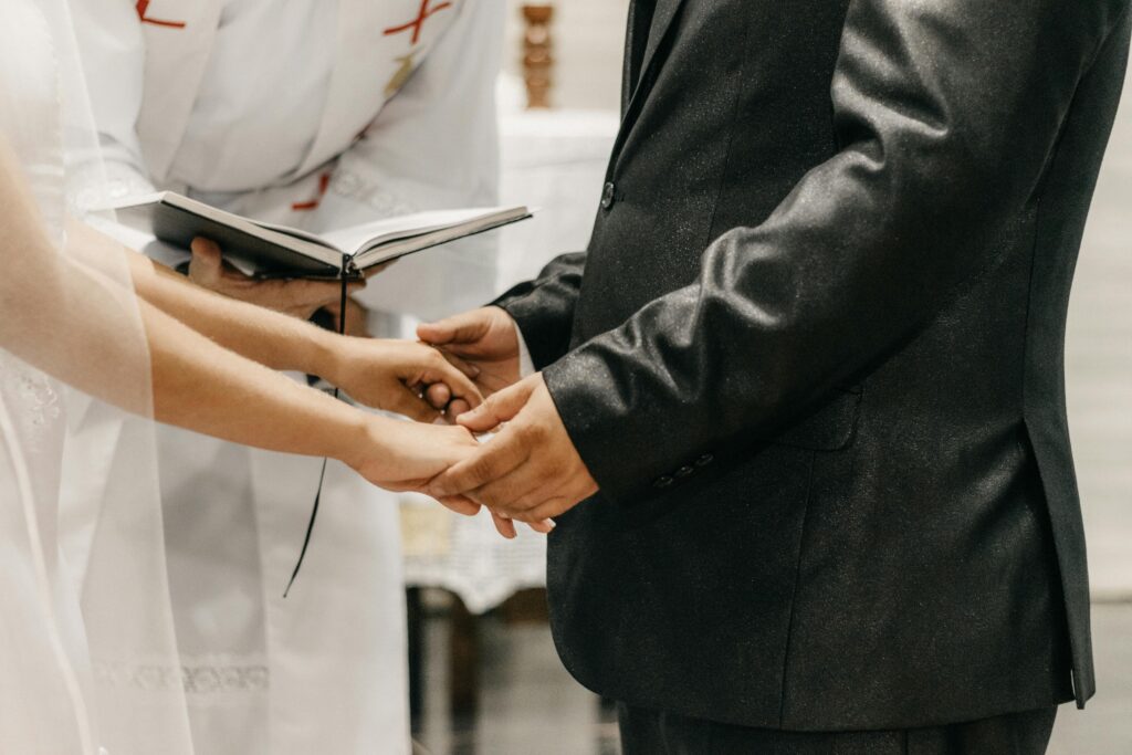 A close-up of a bride and groom exchanging vows during a wedding ceremony.