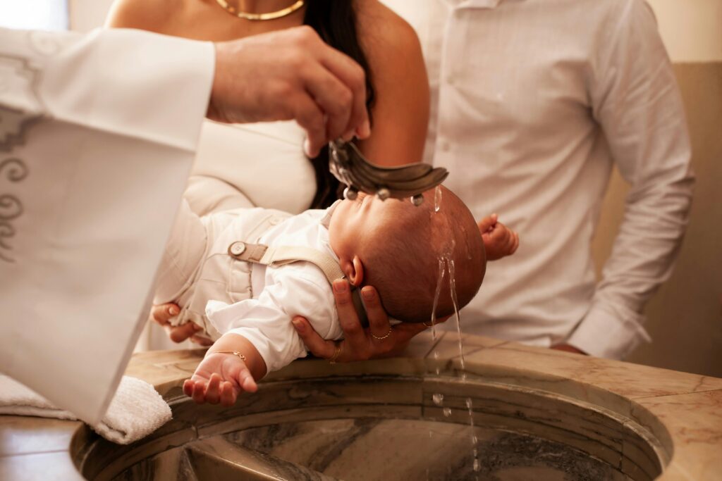 A meaningful baptism ceremony with a baby held by family members in a church setting.